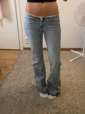 Lågmidjade bootcut jeans - Snygga lågmidjade bootcut jeans med fransar på bakfickorna och benen. 