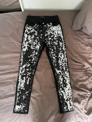 ✨ Svarta jeans med paljetter - Säljer ett par svarta skinny jeans med massor av silverfärgade paljetter på framsidan. Baksidan är helt svart utan paljetter och har två bakfickor. Jeansen har normal midja. Inköpta på Whoops Fashion. Använda fåtalet gånger. Så fint skick! 