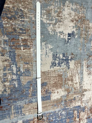 Vitt bälte - Pris kan diskuteras vid snabb affär! Snyggt vitt bälte i skinnimitation med ett stilrent, silverfärgat metallspänne. Bältet har flera hål för justerbar passform och en klassisk, rak design som passar till många olika outfits.