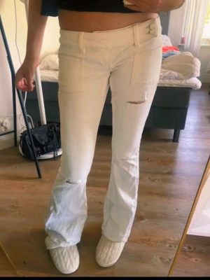 Vita utsvängda jeans med fickor - Säljer ett par vita jeans från Gina. Strålen S och dem är använda 1 gång men har små fläckar bak som förmodligen går bort i tvätten. Skriv om ni vill ha bild!