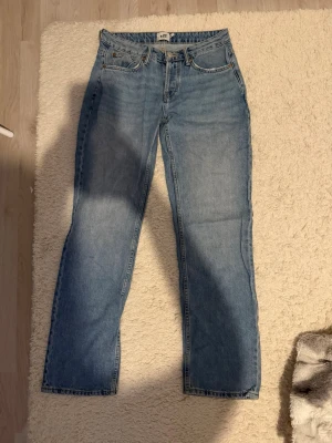 Ljusblå raka jeans från H&M - Säljer ett par ljusblå jeans från H&M med rak passform och klassisk femficksdesign. Jeansen har låg midja och är gjorda i ett mjukt denimtyg. Perfekta för en avslappnad och trendig look.