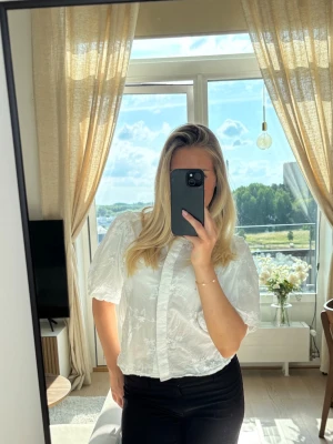 Slutsåld blus från Gina Tricot - Säljer en söt vit blus med puffiga korta ärmar och diskret blommönster i tyget. Har sålts på Gina Tricot för 399 kr, slutsåld 🩷