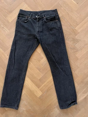 Svarta raka jeans från Our Legacy 80-81 - Säljer ett par svarta raka jeans från Our Legacy, modell 1980-81. Jeansen har klassisk femficksdesign, normal midja och är tillverkade i slitstark denim. Perfekta för dig som gillar en clean och tidlös look.