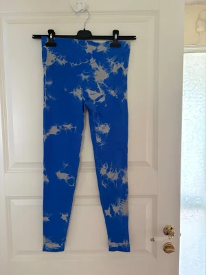 Blå tie dye leggings med hög midja - Snygga blå leggings med vitt tie dye-mönster och hög midja. Stretchigt material som sitter skönt och formar sig efter kroppen. Perfekta för dig som vill ha en färgklick i garderoben och gillar trendiga mönster. Kolla gärna mina andra annonser❗️