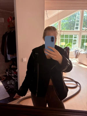 Svart teddyjacka från Zara - Säljer en svart teddyjacka från Zara med stora slag, dragkedjor och bältesdetaljer vid ärmslut och midja. Jackan har mjukt teddyfoder och två fickor med dragkedja framtill. Perfekt för kyliga dagar och ger en cool, oversized look.