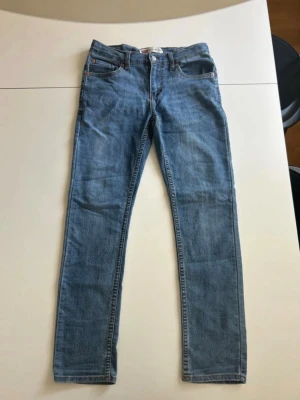 Levi’s Jeans - Snygga ljusblå jeans från Levi's med klassisk femficksdesign och raka ben. Jeansen har normal midja och är tillverkade i ett mjukt denimtyg. Perfekta för en avslappnad och trendig look. Modellen är 512 Slim Taper. Hör av dig om du har några frågor!