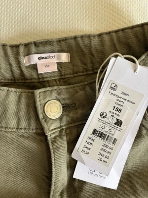 Gröna lågmidjade jeansshorts från Gina Tricot - Snygga lågmidjade gröna jeansshorts från Gina Tricot i modell 'Yeanique low denim'. Shortsen har fransiga kanter, slitna detaljer och klassisk femficksdesign. Helt nya med prislapp!💞