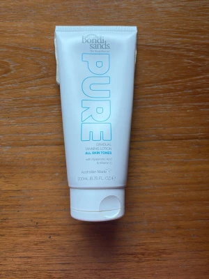 Bondi Sands Pure Tanning Lotion - Bondi Sands Pure Gradual Tanning Lotion för alla hudtoner. Innehåller hyaluronsyra och vitamin C. Tuben är vit med blå text och rymmer 200 ml. Perfekt för dig som vill bygga upp en naturlig solbränna stegvis. Endast testad två gånger. 