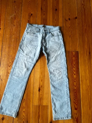 Ljusblå raka jeans från Lee 30/32 - Säljer ett par ljusblå jeans från Lee med klassisk rak passform och fem fickor. Jeansen har en snygg tvättad look och Lee-logga på bakfickan. Perfekta för dig som gillar en avslappnad och tidlös stil.