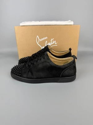 Christian Louboutin Louis Junior Spikes Sneaker Black | 44.5 - Svarta sneakers i gott skick. Box och dustbag ingår. Storlek 44.5, modellen är stor i storleken.