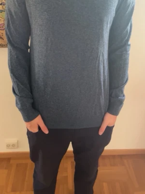 Mörkblå långärmad tröja - En stilren mörkblå långärmad tröja i mjukt material. Tröjan har en enkel, klassisk design med rund halsringning och ribbade muddar vid ärmslut och nederkant. Perfekt för en avslappnad och snygg look.