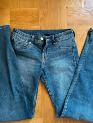 Blå lågmidjade bootcut jeans  - Snygga blå jeans med utsvängda jeans. De är lågmidjade och har en fin passform