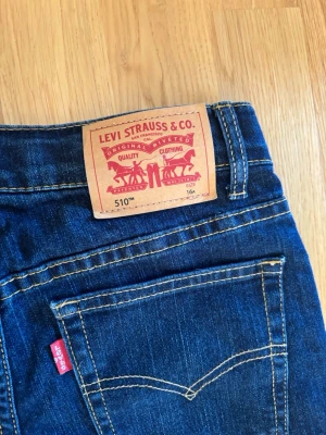 Mörkblå levis jeans  - Säljer ett par mörkblå skinny jeans med klassiska kontrastsömmar och fem fickor. Jeansen har normal midja och raka ben. Perfekta till en avslappnad streetstyle-look.