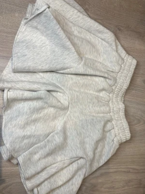Ljusgrå mjukiskjol - Mysig ljusgrå kjol i bomull med bred resår i midjan och avslappnad loose passform. Inbyggda shorts under. Perfekta att ha under sommaren som en bekväm men söt outfit. Aldrig använd. 