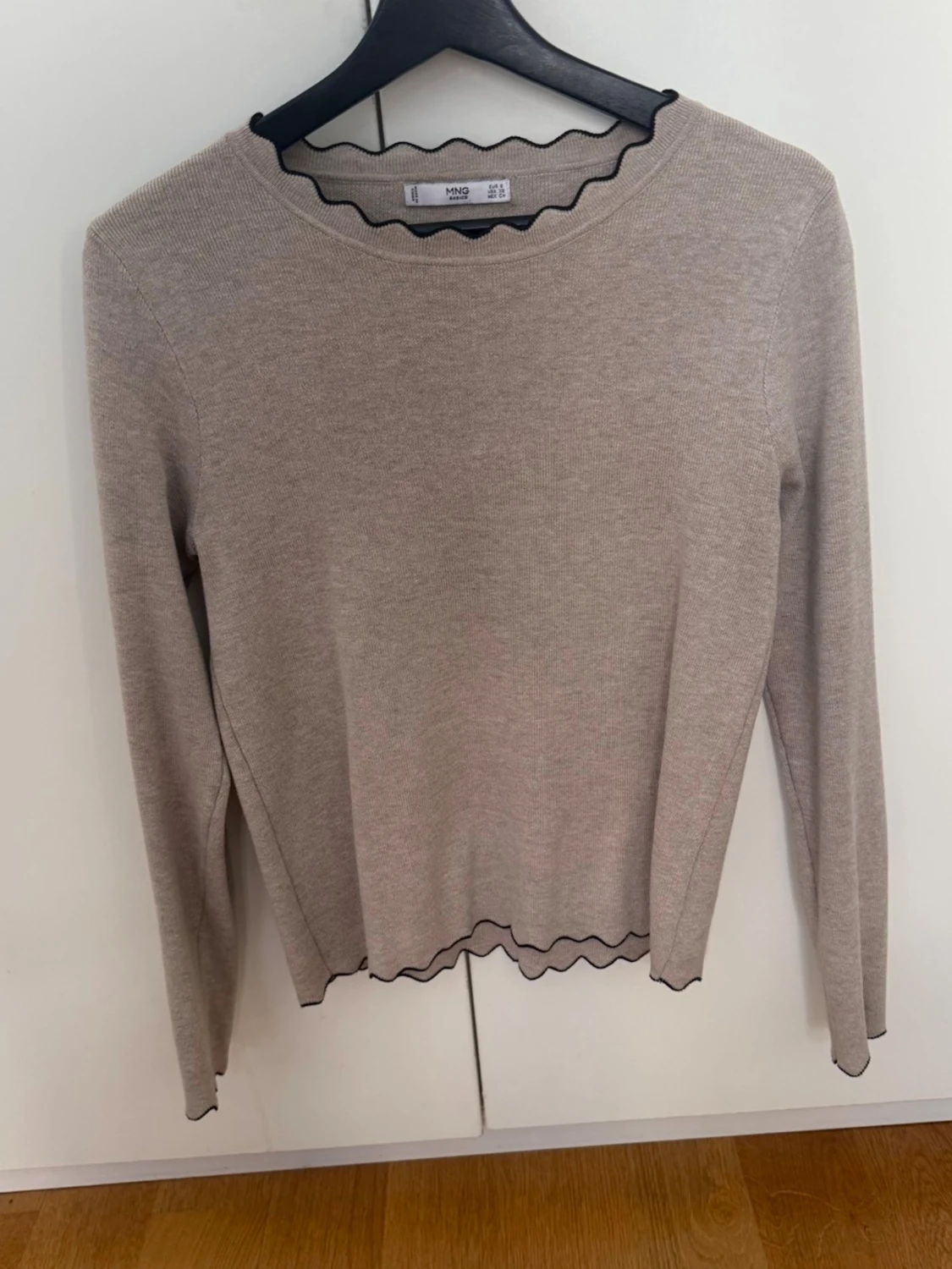 Beige stickad tröja med vågig kant