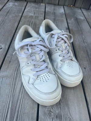 Vita sneakers från Lacoste - Säljer ett par jättefina vit/beigea Lacoste skor med fina detaljer🩵säljer då de tyvärr inte kommer till användning längre. Skriv om ni har några frågor eller vill ha fler bilder så fixar jag de så fort jag kan! Pris kan diskuteras.