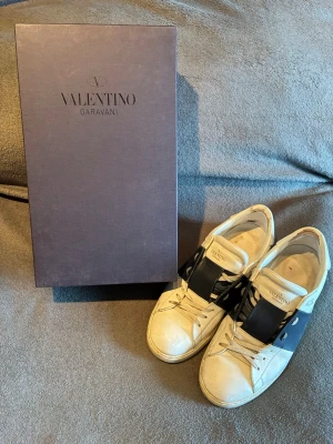 Valentino Open Garavani Sneakers - Skor från Valentino | Storlek: 43 | Färg: vit med marinblåa detaljer | Box följer med vid köp | Sitter en laglapp i hälen | Skriv vid frågor | Pris kan diskuteras vid snabb affär |