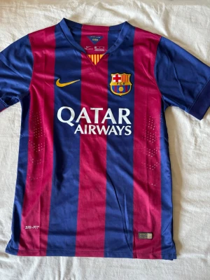 Barcelona Neymar Jr matchtröja - Säljer en FC Barcelona matchtröja från Nike med Neymar Jr och nummer 11 på ryggen. Tröjan har blå och vinröda ränder, gula detaljer och Qatar Airways-tryck på bröstet. Tillverkad i lätt och ventilerande Dri-FIT-material, perfekt för fotboll eller träning.