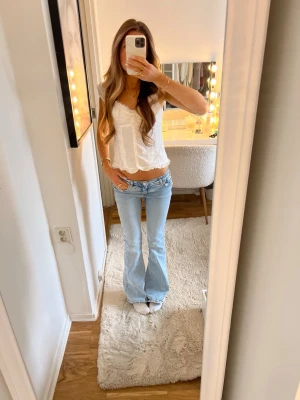 Ljusblå bootcut jeans med låg midja - Säljer ett par ljusblå jeans med bootcut-modell och låg midja. Jeansen har klassiska fem fickor och är tillverkade i ett mjukt denimtyg med lite stretch. Perfekta för dig som gillar en avslappnad och trendig look. Säljer då dem blivit lite stora 🫶🏻💕💕är i nyskick 