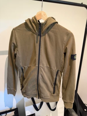 Olivgrön hoodie från Stone Island - Säljer denna stone Island Hoodie därför den är för liten den är lite skavd på några ställen bild finns på det. Hör av dig vid fundering eller liknande🤩🤩