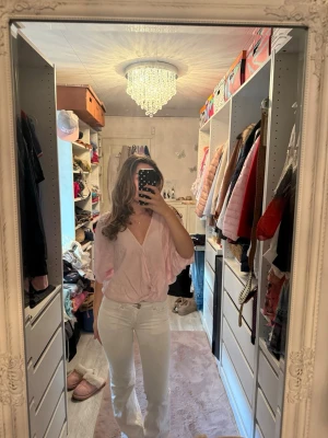 Ljusrosa v-ringad blus - Söt ljusrosa blus med djup v-ringning och avslappnad passform. Blusen har korta ärmar och ett tunt, luftigt material som ger en skön känsla. Perfekt att styla med jeans!☺️