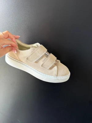 Sneakers med kardborreband - Säljer mina stilrena beige sneakers med två breda kardborreband och tjock vit sula. Varan är nästintill oanvända. Nypris 1300kr