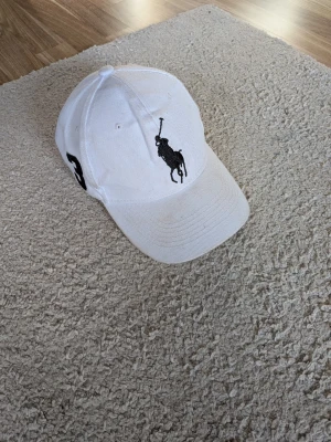 Vintage Ralph Lauren keps - Tjena! Jag säljer en riktigt snygg vintage Ralph Lauren keps! Den är i mycket bra skick med normalt slitage en metal grej är borta men den funkar perfekt ändå! Den är självklart äkta!
