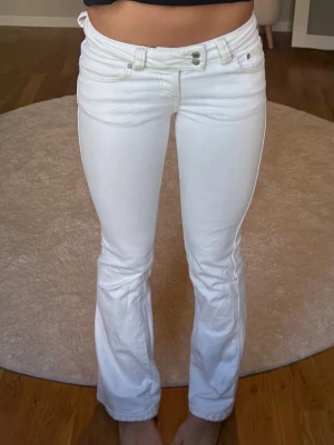 Vita low waist bootcut jeans - Vita low waist bootcut jeans från Lager 157 i strl XS full length. De har detaljer på bakfickorna och även en liten fläck på ena bakfickan som syns på bilden.