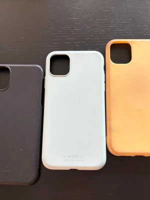 Mobilskal iphone 11 - Använder ej. Den gröna (ideal of sweden) funkar bra men har skador på hörnen och börjar bli sliten. Gula är missfärgad med bortskuren knapp. Svart är skadad i hörnet. Den turkosa (holdit) funkar bra men har skador som inte syns så mycket. (Därav endast frakt)