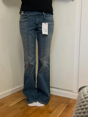 Virala blå Zara jeans - Virala blå lågmidjade bootcut Zara jeansens söm tvärs över sävarsitt ben. Helt nya från Zara i strl 32. 