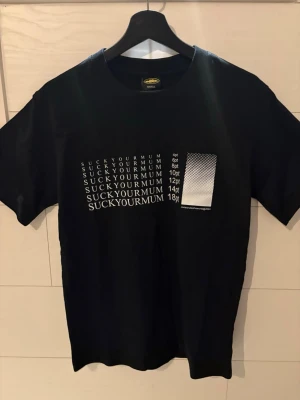 Corteiz svart tröja med grafisk tryck S - Svart t-shirt från Affirmative med vitt grafiskt tryck framtill som visar text i olika typsnittsstorlekar och ett rutmönster. Klassisk rund hals och korta ärmar. Perfekt för dig som gillar streetwear och statement-plagg.