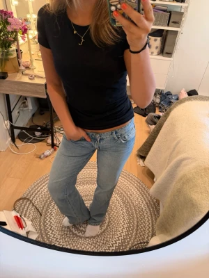 Ljusblå raka jeans med låg midja - Säljer ett par ljusblå jeans med rak passform och låg midja. Jeansen har klassiska fem fickor och stängs med dragkedja och knapp. Perfekta till en avslappnad look och passar till det mesta i garderoben.