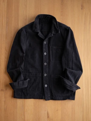 Black Chore Jacket, size M - Stilren svart overshirt i mjuk bomull med klassisk krage och tre utanpåliggande fickor. Knäpps med fem knappar framtill och har långa ärmar. Perfekt lager-på-lager-plagg för en avslappnad look.
