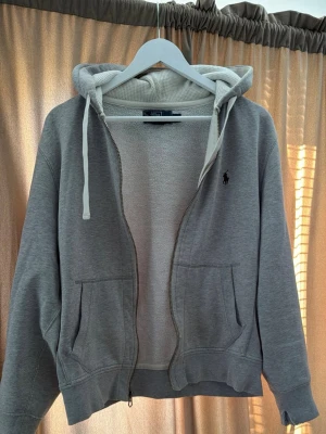 Vintage Ralph Lauren Hoodie  - Säljer denna snygga Vintahe Ralph Lauren hoodie I storlek M men sitter mer som en S. Lite slitage på ärmen (se bilder). Bortsett från det så är den i mint skick den har några år på nacken och är väldigt skön och snygg med vinröd Ralph lauren logga. 