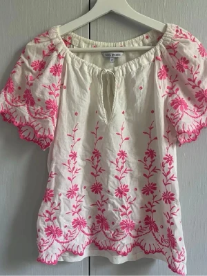 Vit blus med rosa broderi  - Säljer en jättefin blus perfekt till vår och sommar🌸 använd fåtal gånger och är i bra skick. Pris går att diskutera, köparen står för frakten☀️😇