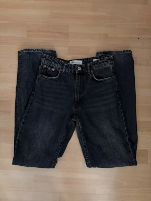 Svarta raka jeans från ZARA - Säljer ett par svarta raka jeans från Zara i storlek 34! Köpta på Vinted men dom passade inte mig, dock är dom precis tvättade! Jeansen har en tvättad look och är tillverkade i kraftigt denimtyg. Passar perfekt till en avslappnad och trendig stil. Midjemått: ca 33cm och Innebenslängden: ca 78cm! Byxorna är midwaist! 