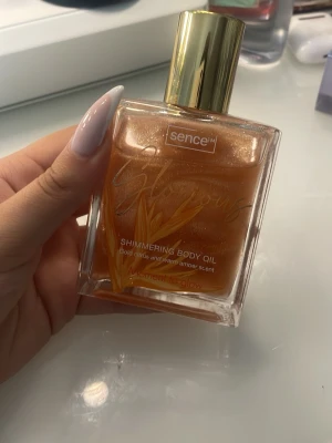 Sence Glorious Shimmering Body Oil - Shimmering Body Oil från Sence Doft av gold citrus och varm amber. Perfekt för att ge huden en glowig finish och extra lyster.