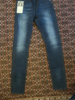 Mörkblå/slim jeans från Lee - Snygga mörkblå skinny jeans från Lee, modell Malone. Jeansen har power stretch för extra komfort och rörelsefrihet. Klassisk femficksdesign och diskreta slitningar framtill. Perfekta för dig som gillar en tight passform och stilren look.