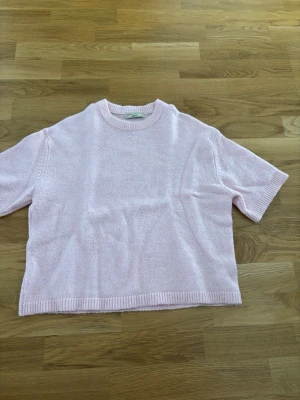 Ljusrosa stickad tröja Gina Tricot - Söt ljusrosa stickad tröja från Gina Tricot i premiumkollektionen med korta ärmar och rund hals. Tröjan har en avslappnad passform och ribbade kanter vid hals, ärmslut och nederkant. Perfekt för lager på lager och en mjuk känsla. Bra kvalitet. 