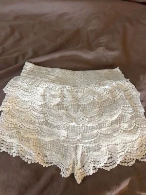 Vita spets-shorts med volang - Säljer ett par äkta vita volang shorts från vingthaisilk💕