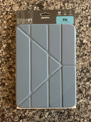 Blå Origami iPad-fodral Pipetto - Snyggt blått Origami-fodral från Pipetto till iPad A16 & 10th Gen. Fodralet har ett geometriskt mönster, ger 1.1m stötskydd och har automatisk sleep/wake-funktion. Kan ställas i fem olika positioner för flexibel användning. 