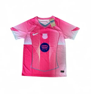 Rosa FC Barcelona matchtröja Nike - Snygg rosa FC Barcelona matchtröja från Nike med vita och blå detaljer. Tröjan har korta ärmar, rund hals och tryckta loggor för både Nike och Barcelona samt sponsortryck på bröstet. Tillverkad i lätt och ventilerande funktionsmaterial.