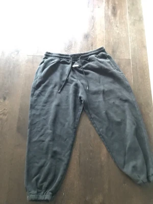 Svarta mjukisbyxor från Hollister - Ett par svarta mjukisbyxor från Hollister med dragsko i midjan och resår vid bensluten. Tillverkade i mjukt och skönt material, perfekta för chill dagar. Klassisk passform och enkel design med diskret logga framtill.