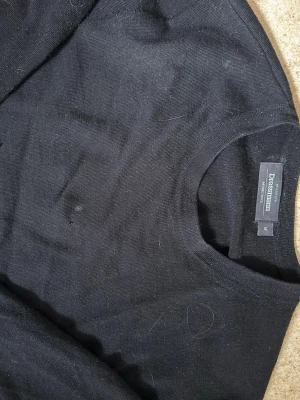 Svart stickad merinoull tröja Dressmann - Klassisk svart stickad tröja i merinoull från Dressmann i storlek M. Tröjan har rund halsringning och ribbade muddar vid ärmslut och nederkant. Perfekt basplagg i mjukt material som funkar till det mesta. Säljs för 249kr. Kontakta mig om du har frågor eller vill lägga bud.