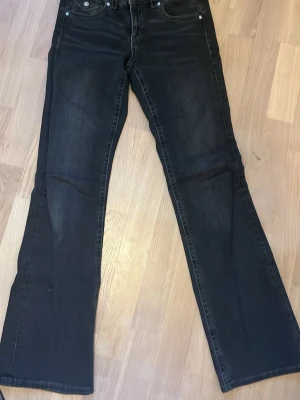 Svarta bootcut jeans från Gina Tricot - Säljer ett par svarta bootcut jeans från Gina Tricot, på grund av storlek. Har endast används fåtal gånger och är i mycket bra skick. Jeansen har klassisk femficksmodell, silverfärgade nitar och knapp samt markerade sömmar. Perfekta till en trendig vardagslook och passar till det mesta.