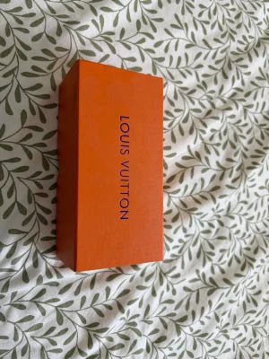 Louis Vuitton svarta solglasögon - Snygga svarta solglasögon från Louis Vuitton med klassisk design. Kommer med originalförpackning, putsduk och fodral. Glasögonen har mörka linser och en stilren form som passar till många looks.