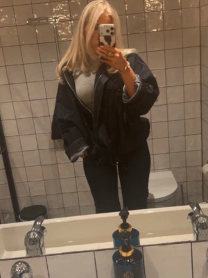 Oversized mörkblå jeansjacka - Snygg oversized jeansjacka i mörkblå denim med breda ärmar och klassisk krage. Jackan har en avslappnad passform och synliga sömmar som ger en cool och trendig look. Perfekt att slänga över en hoodie eller t-shirt för en casual vibe.