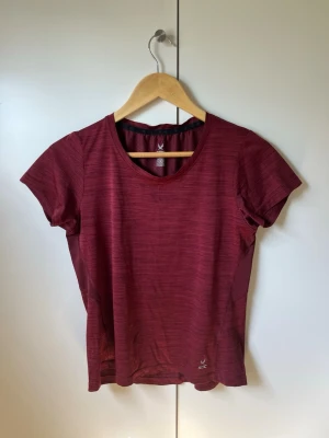 Vinröd sport-t-shirt SOC - Snygg vinröd sport-t-shirt från SOC med rund hals och korta ärmar. Tillverkad i ett lätt och snabbtorkande funktionsmaterial, perfekt för träning. Diskret mönster i tyget och reflexdetalj på ryggen för extra synlighet. Mycket bra och skulle behållt den om min överkropp inte var så lång. Och då T-shirten blir för kort☺️