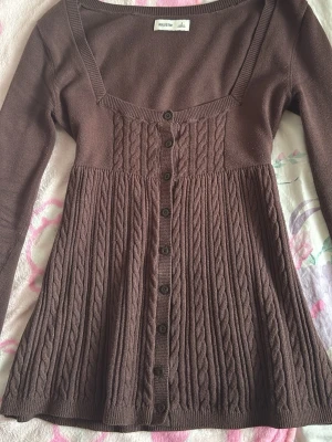 Brun babydoll Hollister - Brun babydoll långärmad med knappar från hollister i storlek S. Defekter:vanliga tecken på använding, nopprig/urtvättad❣️ Skicka gärna prisförslag det är inte ett satt pris!❣️