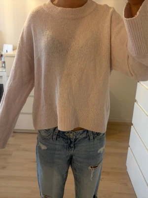 Ljusrosa stickad tröja Gina Tricot - Mysig ljusrosa stickad tröja från Gina Tricot med rund halsringning och breda ribbade muddar vid ärmslut och nederkant. 